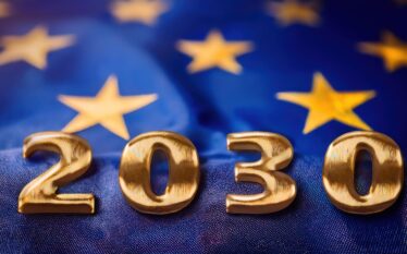 Złoty napis „2030” na tle flagi Unii Europejskiej symbolizujący cele klimatyczne UE