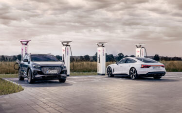 Dwa elektryczne modele Audi podczas ładowania na stacji IONITY w otwartej przestrzeni