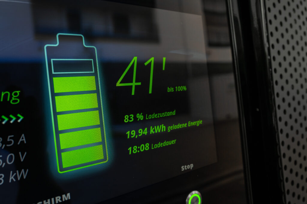 Tekst alternatywny: Ekran ładowarki samochodu elektrycznego z informacjami o poziomie naładowania baterii.