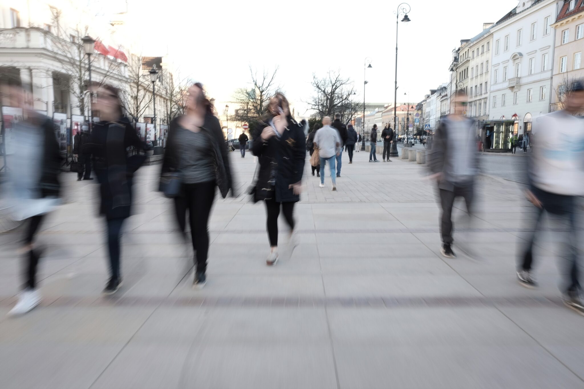 Ludzie spacerujący po miejskim deptaku, rozmyci ruchem