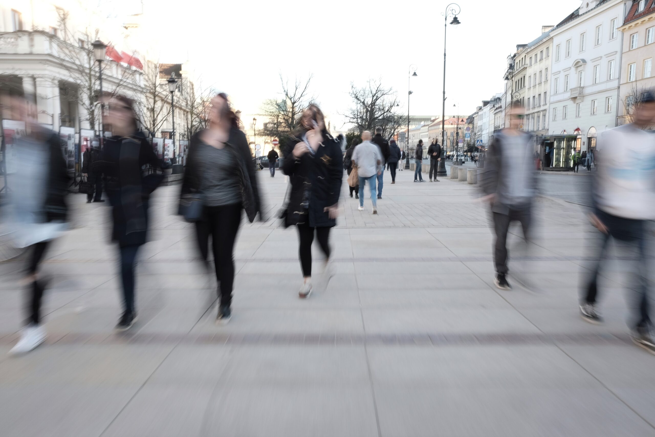Ludzie spacerujący po miejskim deptaku, rozmyci ruchem