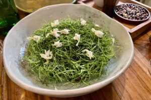 Zielone danie z jadalnymi kwiatami w Celele