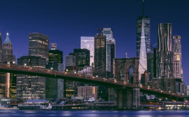 Panorama nowojorskiego Manhattanu nocą z mostem Brooklińskim na pierwszym planie