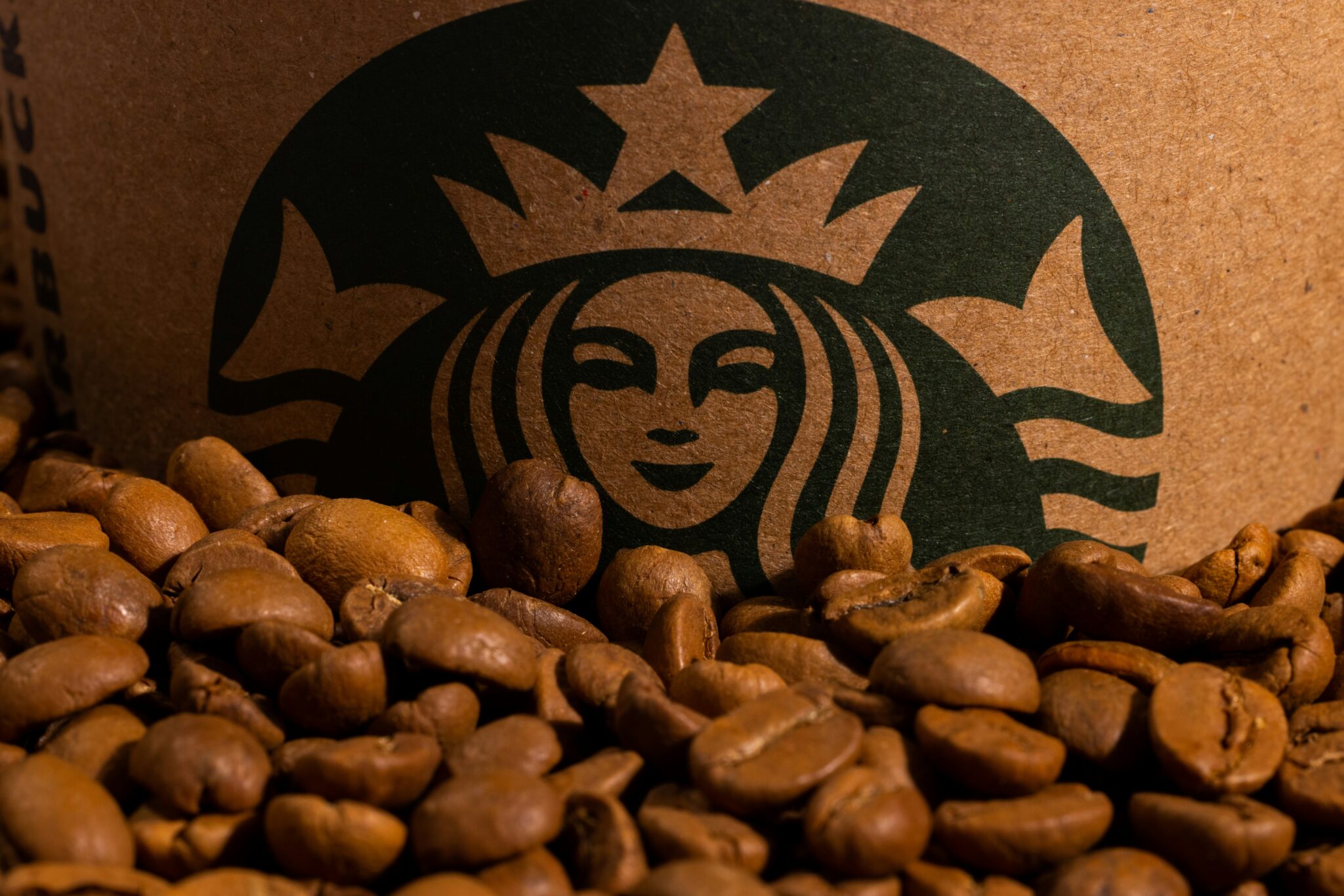 Logo Starbucks na tle ziaren kawy