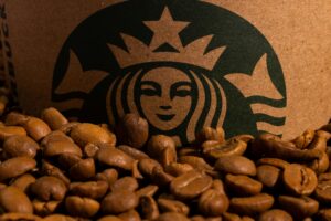 Logo Starbucks na tle ziaren kawy