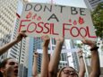 Uczestnicy protestu klimatycznego z transparentem "Don't be a fossil fool"