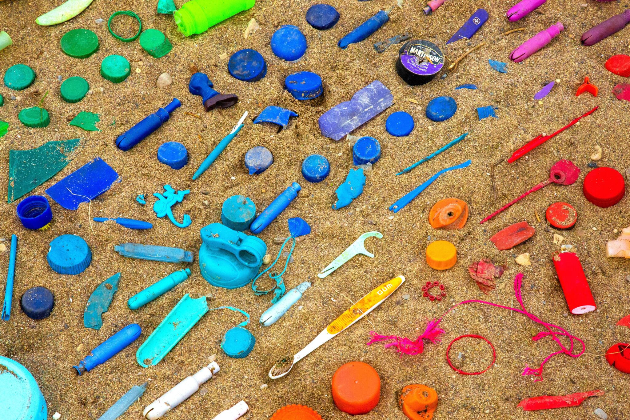 Kolorowe odpady plastikowe na piaszczystej plaży