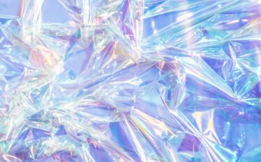 Zbliżenie na błyszczącą, przezroczystą folię plastikową w odcieniach niebieskiego i różowego