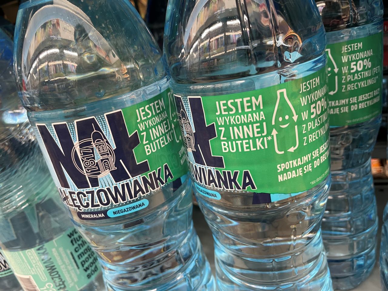 Butelki wody Nałęczowianka z hasłami o recyklingu na etykiecie
