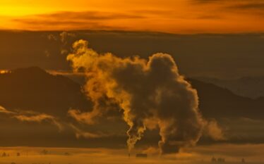 Kominy przemysłowe emitujące dwutlenek węgla o zachodzie słońca