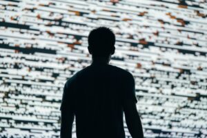 Sylwetka mężczyzny przed dużym ekranem z danymi ilustrująca analizę raportu OECD o zrównoważonym rozwoju