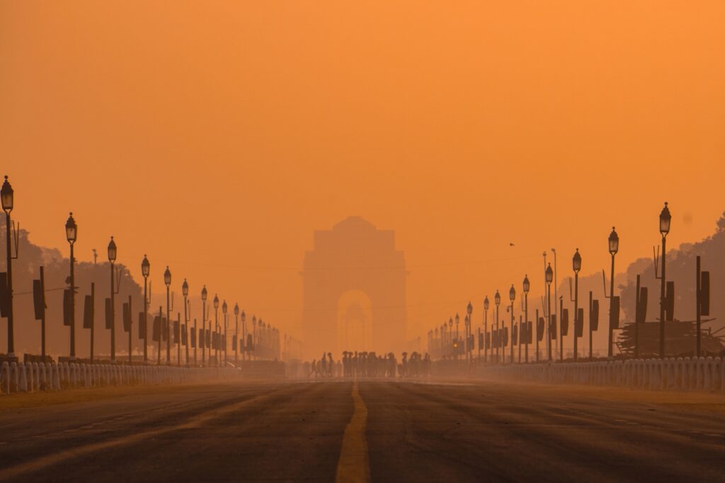 Widok na India Gate w Delhi spowity gęstym smogiem o pomarańczowym odcieniu nieba