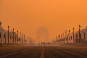 Widok na India Gate w Delhi spowity gęstym smogiem o pomarańczowym odcieniu nieba