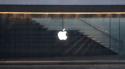 Logo Apple na szklanej fasadzie budynku w deszczu