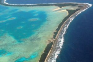Atol Tuvalu z lotu ptaka otoczony turkusową laguną i oceanem.