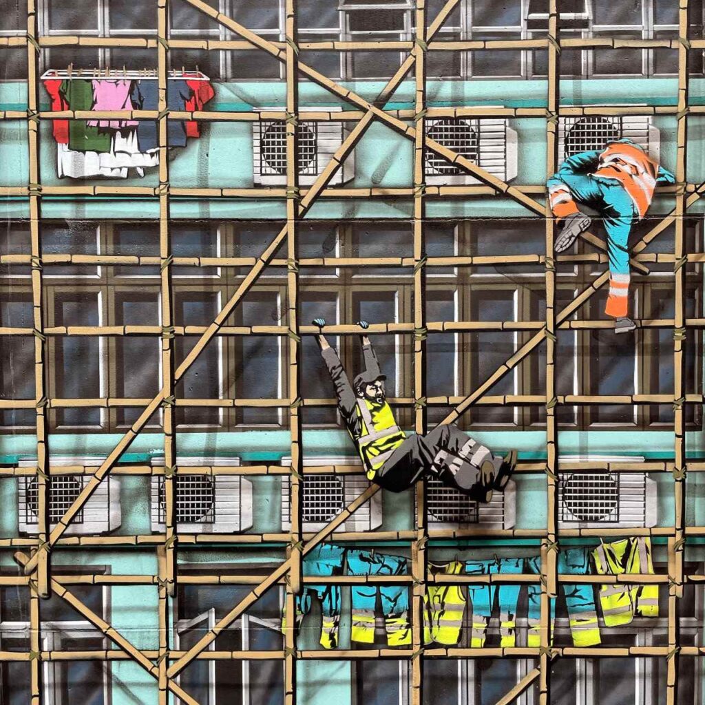 Mural przedstawiający robotników na bambusowych rusztowaniach na fasadzie