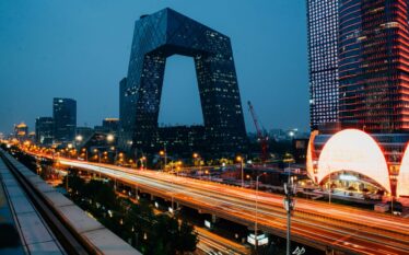 Pekin nocą z nowoczesną architekturą i oświetlonymi wieżowcami symbolizującymi rozwój technologiczny i energetyczny Chin