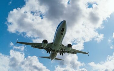 Samolot pasażerski podczas lądowania na tle chmur