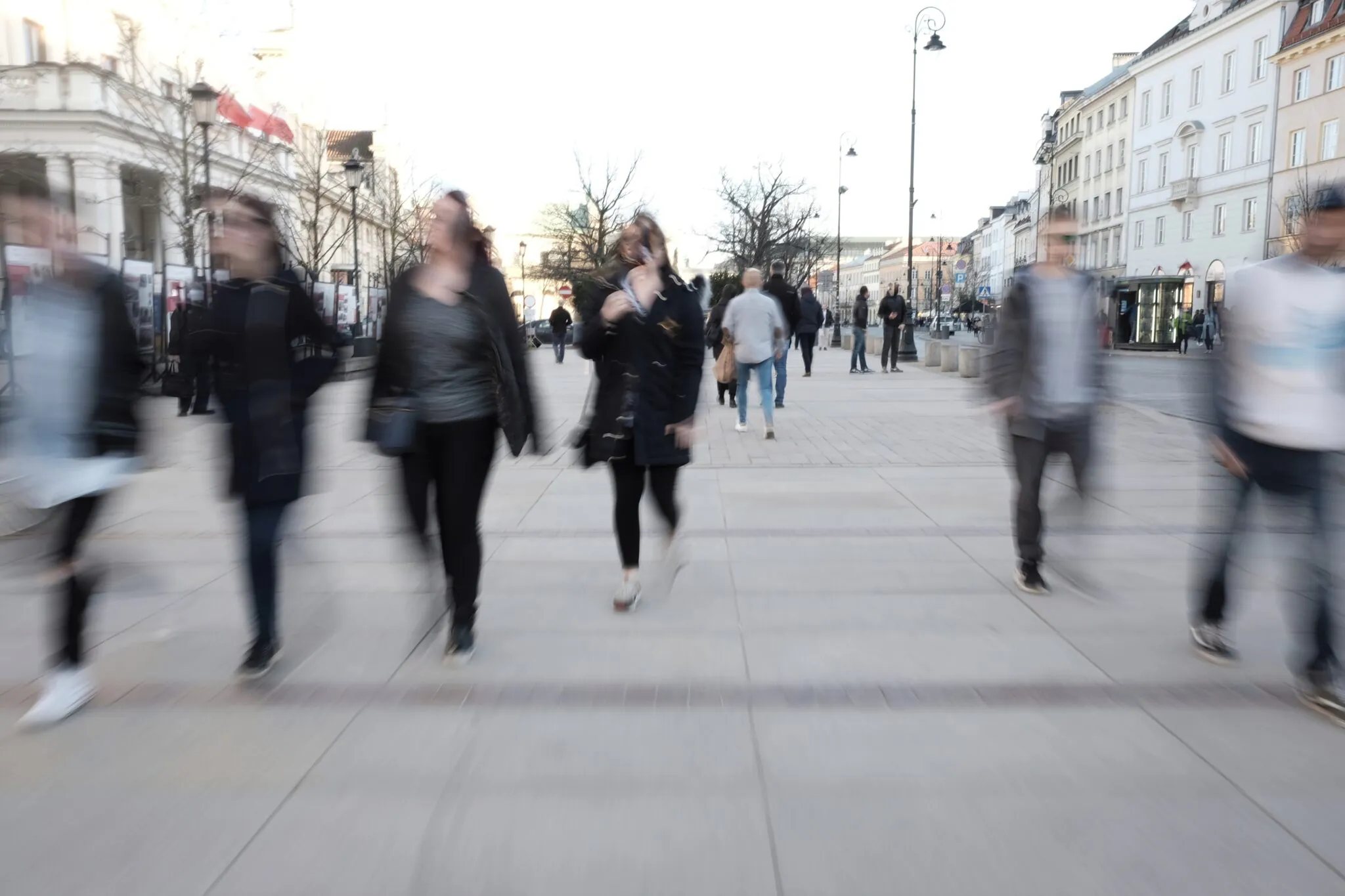 Ludzie spacerujący po miejskim deptaku, rozmyci ruchem