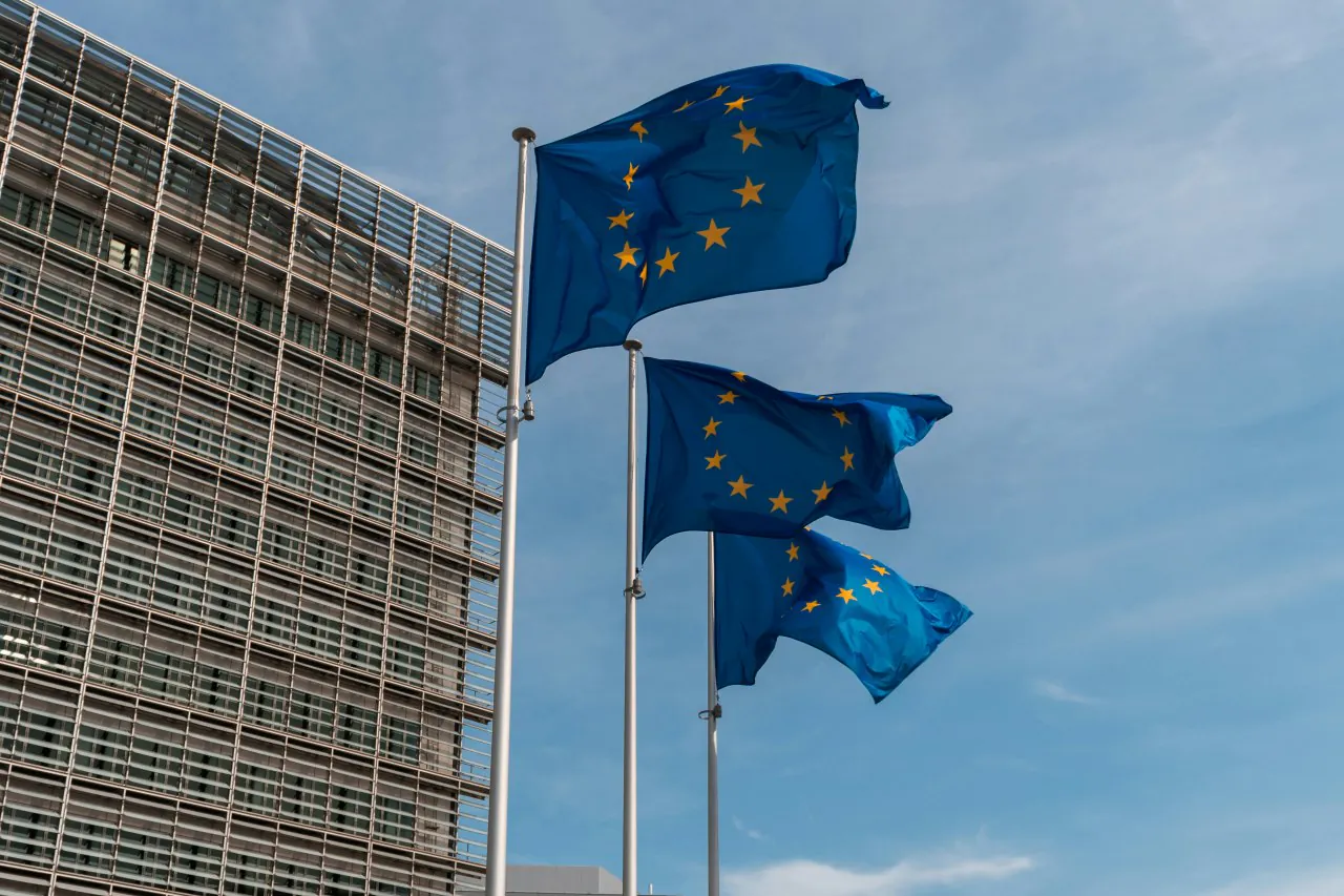 Flagi Unii Europejskiej powiewające przed budynkiem Komisji Europejskiej w Brukseli